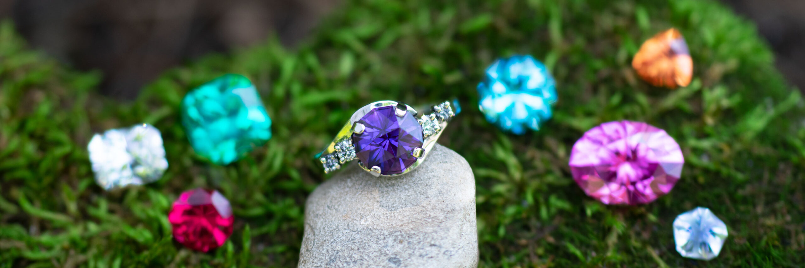 A selection of unique, custom-cut gemstones set in handcrafted jewelry, showcasing the artistry and precision of custom jewelry design.
