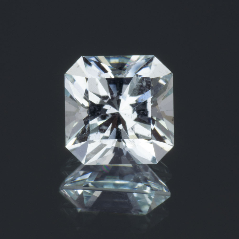 An image of a square cut, light blue aquamarine against a dark background.