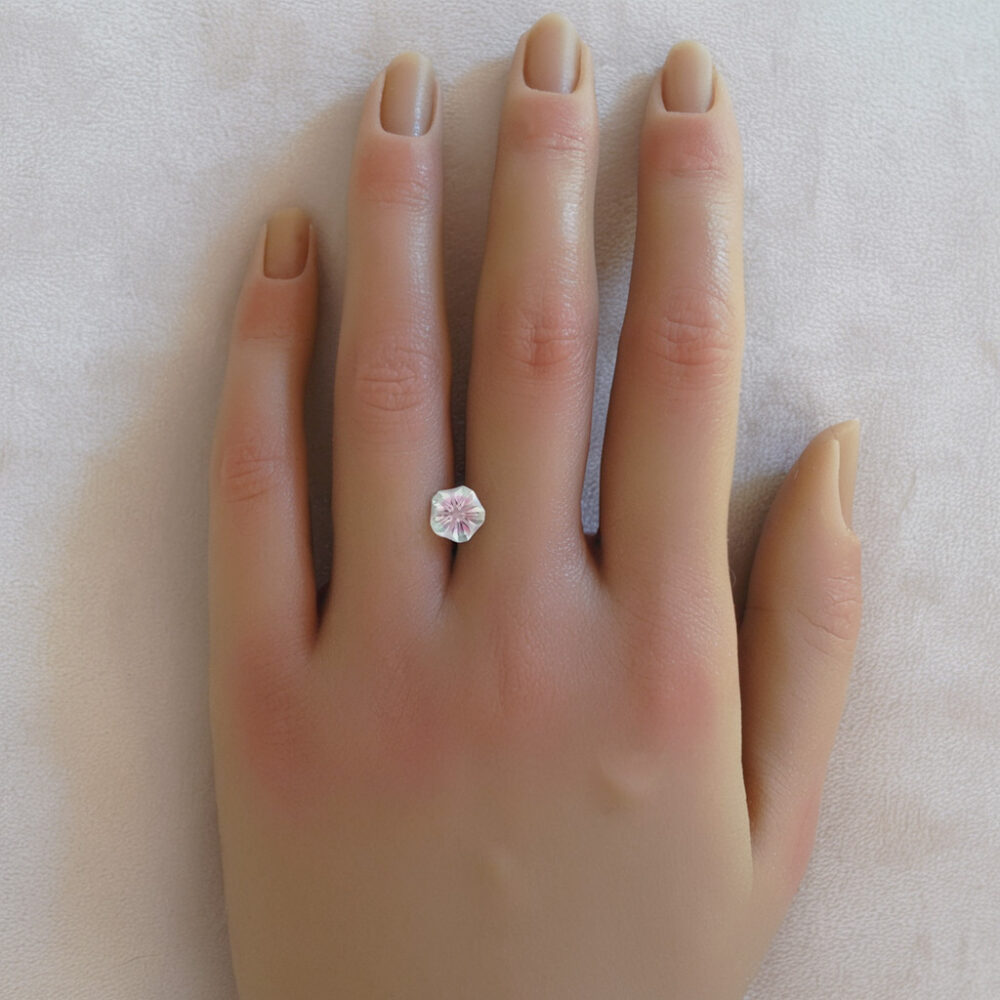 An image of a bi-color green and pink lab-created sapphire cut in a Hanami design.