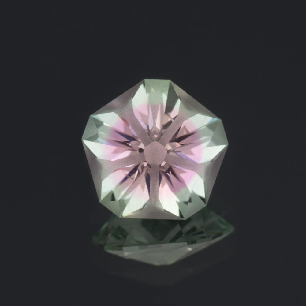 An image of a Hanami cut bi-color lab-created sapphire in green and pink.