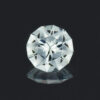A closeup of a round aquamarine gemstone, cut with frosted main facets.