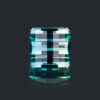 A picture of an opposed bar cut, also known as a pixel cut, teal lab-created sapphire.
