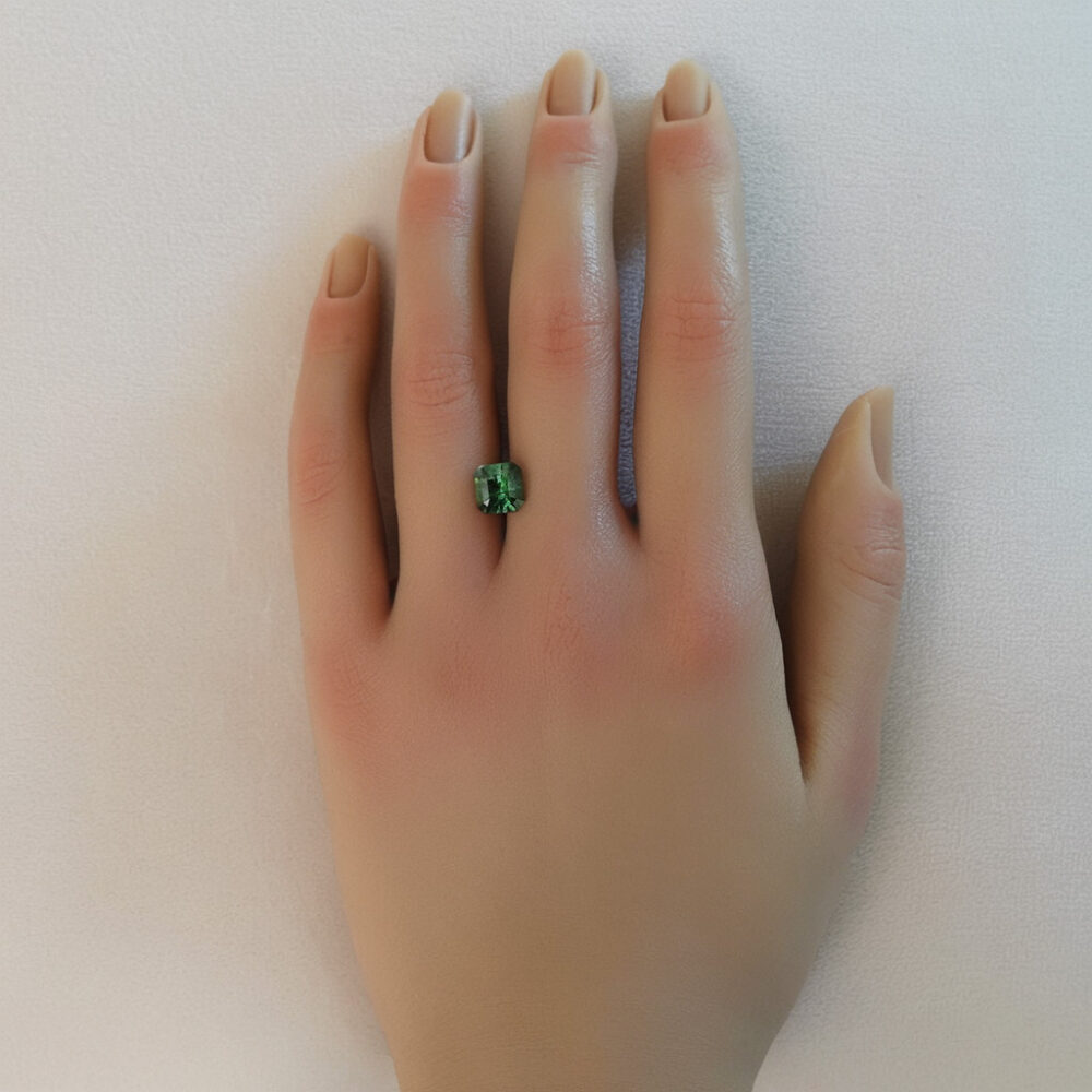A photo of our square cut green tourmaline on a hand.