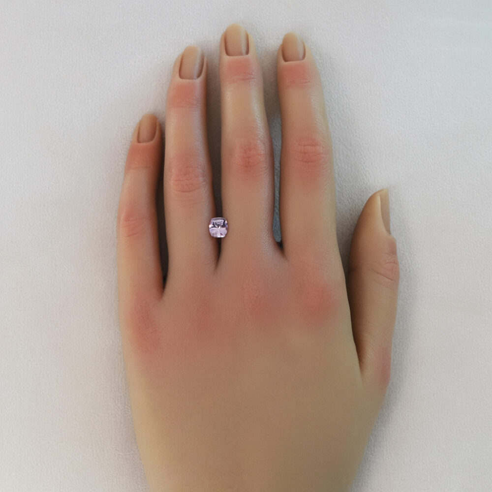 An image of a light pastel pink spinel on a woman's hand.