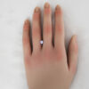 A 0.67 carat round tanzanite shown on a hand for perspective.