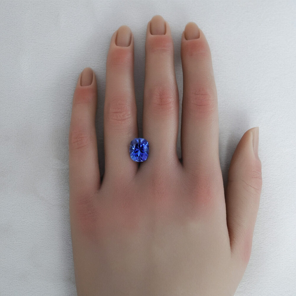 A large 6 carat lab-grown sapphire shown on a hand.