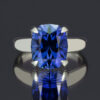 A large, brilliantly cut lab-created blue sapphire gemstone set in a classic 14k white gold tapered band.
