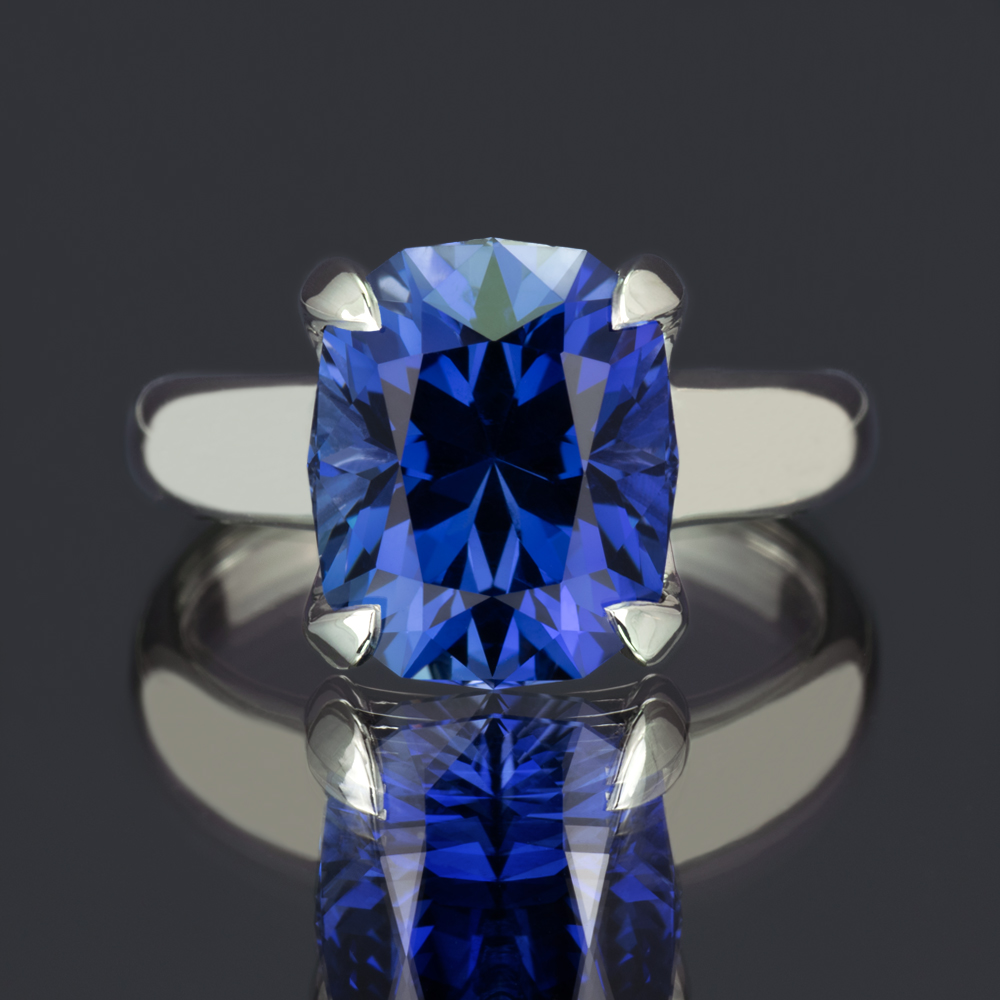 A large, brilliantly cut lab-created blue sapphire gemstone set in a classic 14k white gold tapered band.